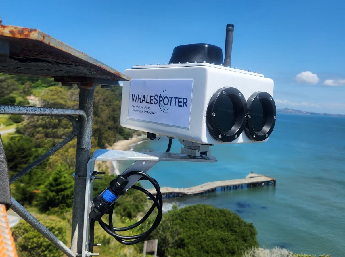 A specialized camera mounted on a platform with a bay in the background.