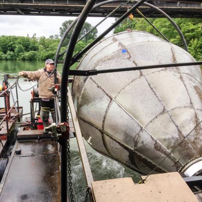 Dean Toba, a scientific technician with the Washington Department of Fish and Wildlife, operates the agency’s screw trap on the Skagit River. The trap helps biologists estimate the number of juvenile salmon leaving the river each year. Photo: Christopher Dunagan, PSI