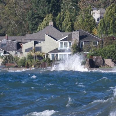 Waves crashing in front of a house. Photo: James Kinney