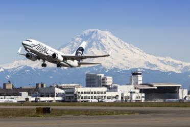 Alaska Airlines 737 taking off from Sea-Tac Airport with Mt Rainier and Central Terminal in background. Photo: Port of Seattle by Don Wilson