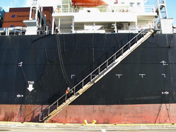A state inspector boards a container ship at the Port of Seattle to check on ballast water and determine whether procedures were followed to reduce the risk of invasive species being released into Puget Sound.  Photo: WDFW