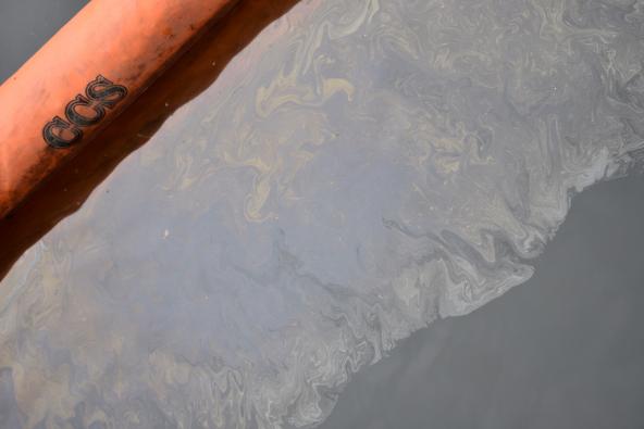 Close up of oil on water collected behind an oil boom. Photo: WA Department of Ecology (CC BY-NC 2.0) https://flic.kr/p/2f25AiG