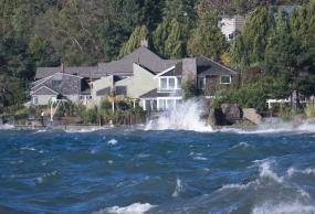 Waves crashing in front of a house. Photo: James Kinney